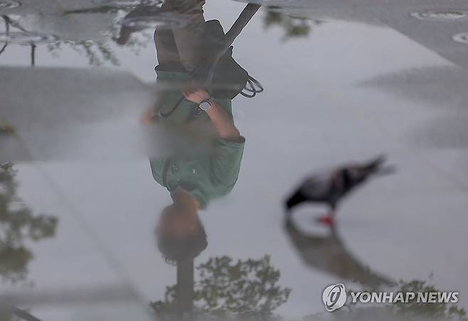 빗물이 비치는 출근길 [연합뉴스 자료사진]