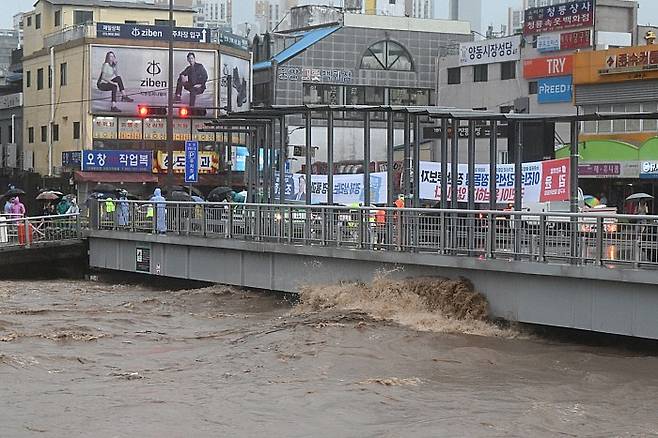 2025년 7월17일 오후 광주 서구 양동복개상가 인근 태평교 밑으로 흐르는 광주천 강물이 범람 수위까지 도달한 모습. 광주 도심 투수층이 사라지면서 빗물이 일시에 광주천으로 쏟아진 결과 도시홍수 위험에 상시 노출돼 있다. 뉴시스