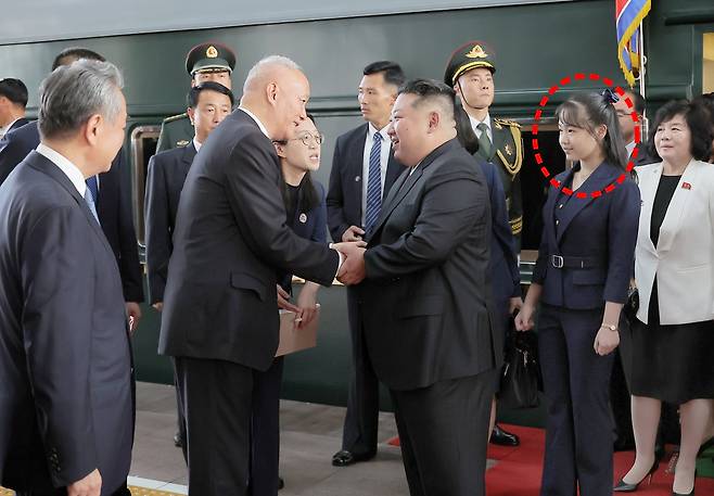 2일 오후 중국 수도 베이징 베이징역에 전용열차편으로 도착한 김정은 북한 국무위원장이 차이치 중국공산당 중앙서기처 서기(당 중앙정치국 상무위원)의 환영을 받고 있다.뒤에 딸 김주애(점선)가 서 있다./조선중앙통신 연합뉴스