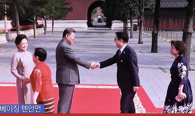 3일 서울 중구 서울역에 설치된 TV에 중계되는 중국 전승절 열병식 행사에서 시진핑 중국 국가주석과 우원식 국회의장이 악수하는 장면이 나오고 있다.  뉴시스.