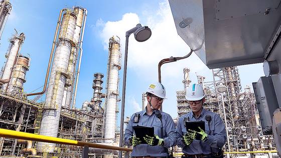 현장 근로자들이 GS칼텍스 여수공장 정유 생산 공정에서 수율 최적화 AI 모델의 분석 내용을 태블릿으로 살펴보고 있다. [사진 GS칼텍스]