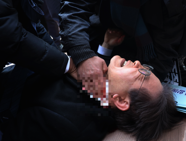 ▲ 지난 2024년 1월 2일 부산 가덕도 신공항 부지를 둘러본 후 기자들과 문답을 진행하던 중 왼쪽 목 부위를 습격당해 피를 흘린 채 쓰러진 모습 [연합뉴스 자료사진]