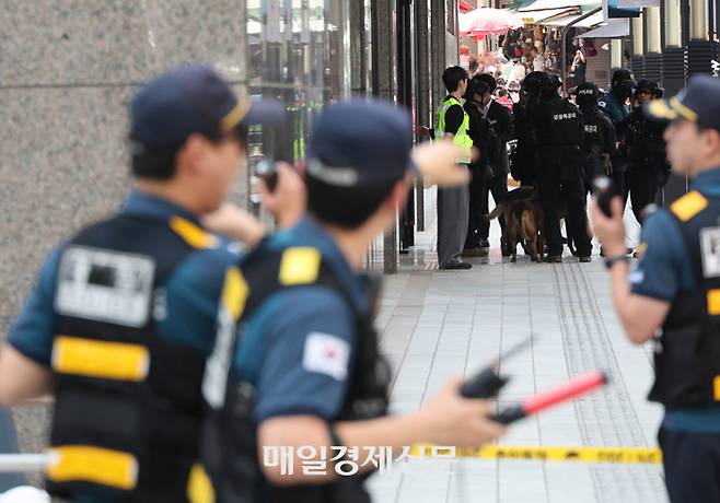 지난달 5일 서울 중구 명동 신세계백화점 본점에 폭발물을 설치했다는 협박 글이 온라인 커뮤니티에 게시됐다는 신고를 받고 출동한 경찰이 현장을 수색하고 있다. [이충우 기자]