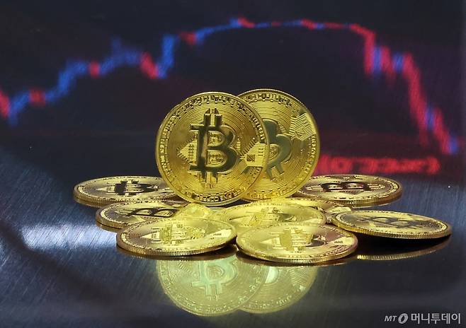 서울 강남구 서초구 빗썸라운지 강남본점에서 비트코인 모형이 놓인 바닥에 코인 시세 그래프가 비치는 모습.