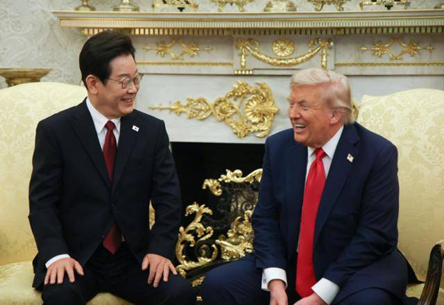 이재명 대통령이 지난달 25일 미국 워싱턴 백악관 대통령 집무실(오벌오피스)에서 도널드 트럼프 미국 대통령과 한미 정상회담을 하며 함께 웃고 있다. 워싱턴=연합뉴스