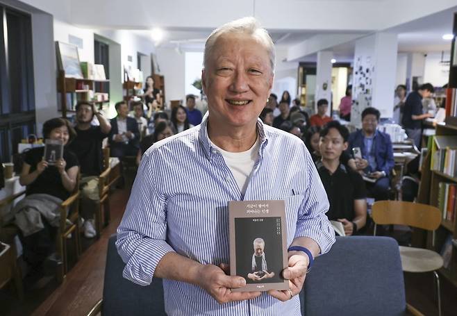 박용만 전 대한상공회의소 회장이 두 번째 저서 <지금이 쌓여서 피어나는 인생>을 출간했다. 지난 3일 저녁 서울 종로구 서촌 북카페에서 출간 기념 북콘서트에서 박 전 회장이 참석자들과 함께 책을 들어보이고 있다.   임형택 기자