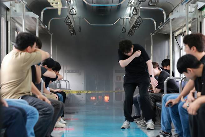 4일 오후 경기도 고양시 지축차량기지에서 전동차 화재 시연이 열린 가운데 불이 난 전동차 객실에서 승객을 가정한 서울교통공사 직원들이 대피하고 있다. (공동취재) /사진=뉴스1