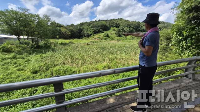 ▲방마마을 주민 A씨가 국정원 인근 규제로 농사조차 짓지 못하는 사유지를 가리키며 답답함을 토로하고 있다. ⓒ프레시안