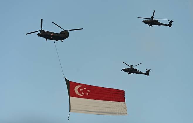 9일(현지시간) 싱가포르 파당에서 열린 국경일 퍼레이드에서 국기를 실은 헬리콥터가 하늘을 가로지르고 있다. 사진은 기사 내용과 무관함. 2025.8.9 EPA 연합뉴스