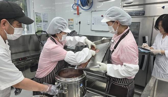 ▲ 수원 망포중학교 조리실에서 조리실무사들이 기부할 음식을 포장하고 있다.