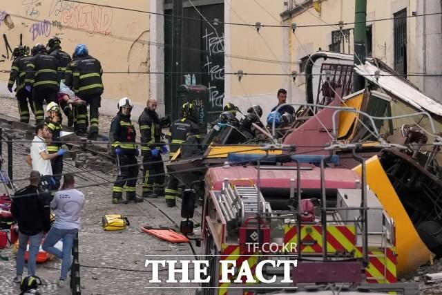 3일(현지 시간) 포르투갈 리스본에서 발생한 전동 케이블 전차 '푸니쿨라' 탈선 현장에서 소방관들이 희생자 시신을 옮기고 있다. /뉴시스