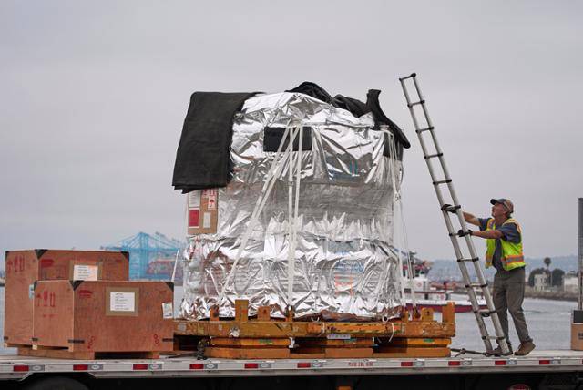 한 트럭 운전사가 지난달 1일 미국 캘리포니아주(州) 롱비치 항구에서 일본산 고정밀 의료기기를 운송하기 전 보호 커버를 씌우고 있다. 롱비치=AP 연합뉴스