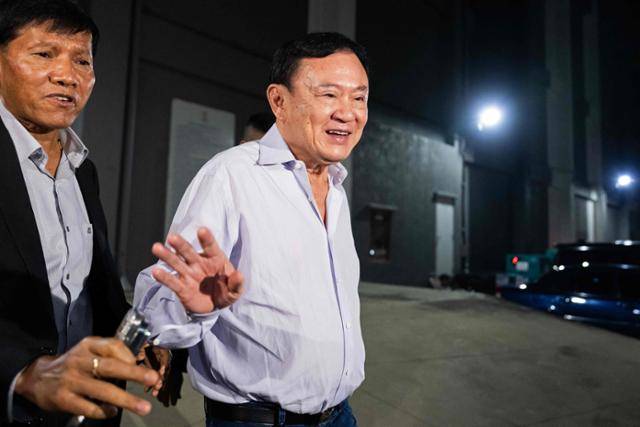 탁신 친나왓 전 태국 총리가 지난달 29일 방콕 푸어타이당 당사를 나서며 지지자들에게 인사하고 있다. 방콕=AFP 연합뉴스