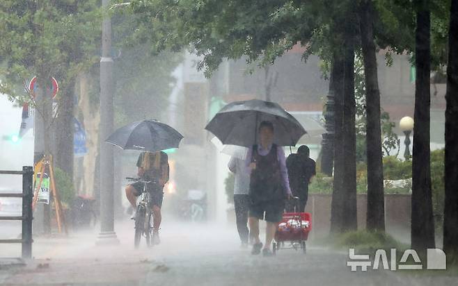 [대구=뉴시스] 이무열 기자 = 대구 지역 호우경보가 발효된 17일 대구 남구청네거리 인근에서 우산을 쓴 시민들이 이동하고 있다. 2025.07.17. lmy@newsis.com