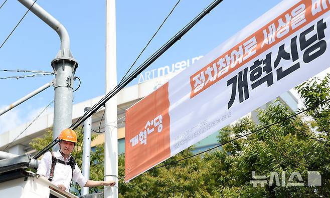 [대구=뉴시스] 이무열 기자 = 이준석 개혁신당 대표가 5일 대구 북구 경북대학교 북문 앞에서 정당 가입 독려 현수막을 직접 게첩하고 있다. 2025.09.05. lmy@newsis.com