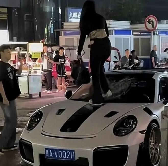 지난 2일 중국 구이저우성 구이양시에서 한 여성이 흰색 포르쉐 차량 위에 올라가 앞유리를 걷어차고 있는 장면. 왕이신문