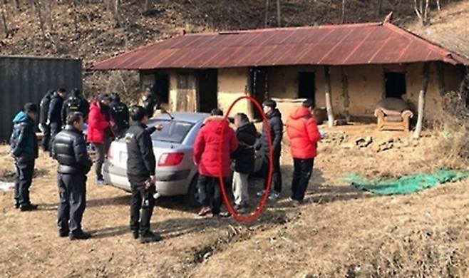 2017년 1월 홍천군의 한 폐가에서 한씨(빨간색 동그라미)가 범행을 재연하고 있다.  연합뉴스