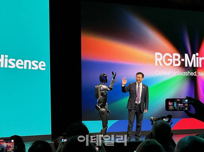 5일(현지시간) 독일 베를린에서 개막한 ‘IFA 2025’에서 중국 가전 기업 하이센스의 휴머노이드 로봇이 연설 도중 올라와 데니스 리 하이센스 비주얼테크놀로지 사장과 인사하고 있다.(사진=공지유 기자)