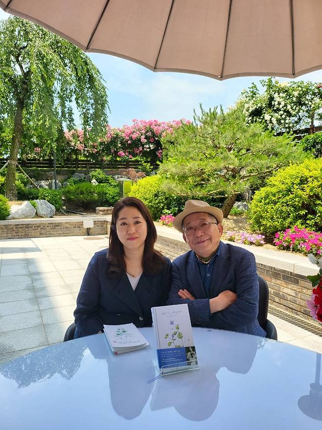 나민애 교수와 아버지인 나태주 시인. 앞에 놓인 책은 두 사람이 함께 쓴 책 '나만 아는 풀꽃 향기'(넥서스). 나 교수는 책에서 "가난이 반갑지는 않았지만 원망스럽지도 않았다"며 "그건 '우리'의 것이었으니까요. 아버지가 나 대신 가난을 다 막아 줬으니까요."라고 썼다./나민애 제공