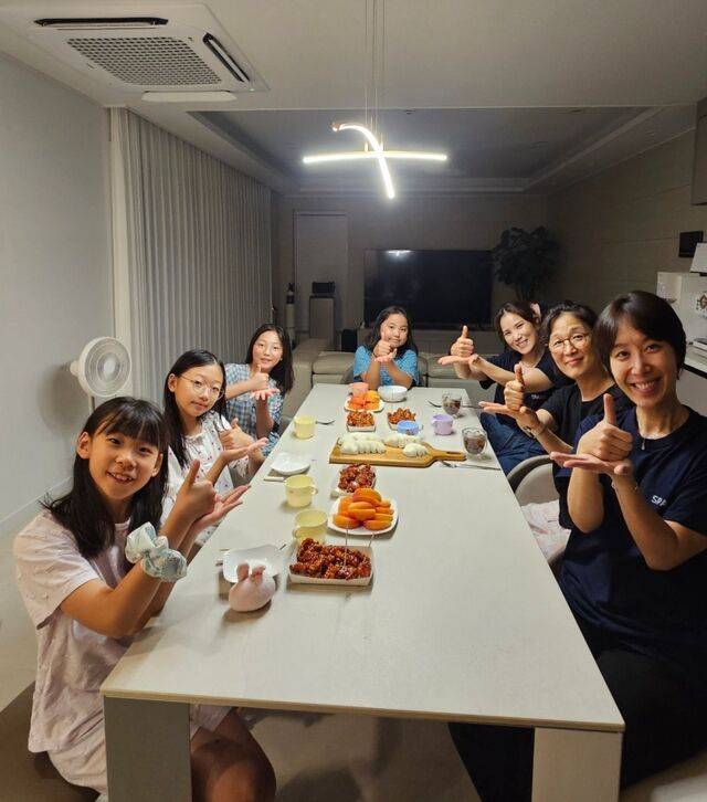 남유미(오른쪽 맨 앞) 집사가 식탁에 둘러앉은 아이들과 ‘엄지 척’ 포즈로 기념촬영 하는 모습. 원주충정교회 제공