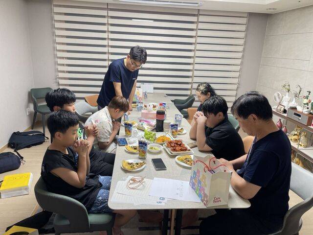 전경희 집사 자택 홈스테이에 참여한 이들이 함께 야식을 즐기기 전 기도하고 있다. 원주충정교회 제공