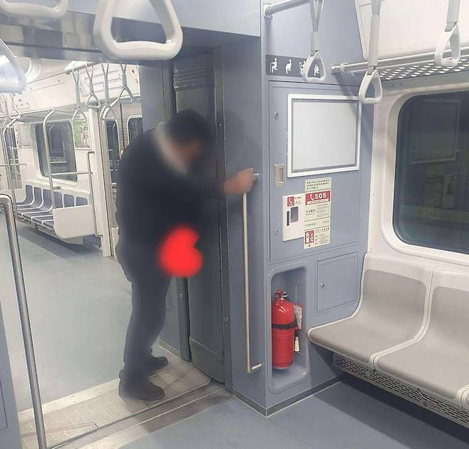 만취 상태로 보이는 중년 남성이 지하철 연결 통로에서 소변을 보는 듯한 장면./사진=보배드림 화면캡쳐