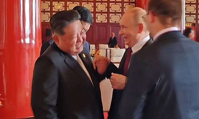 북한 조선중앙TV는 6일 김정은 국무위원장의 지난 2~4일 중국 방문을 담은 기록영화를 방영했다. 사진은 중앙TV가 공개한 김정은 위원장과 블라디미르 푸틴 러시아 대통령이 열병식 행사가 끝난후 만나서 대화하는 도중 파안대소하는 모습. 평양=조선중앙TV·연합뉴스