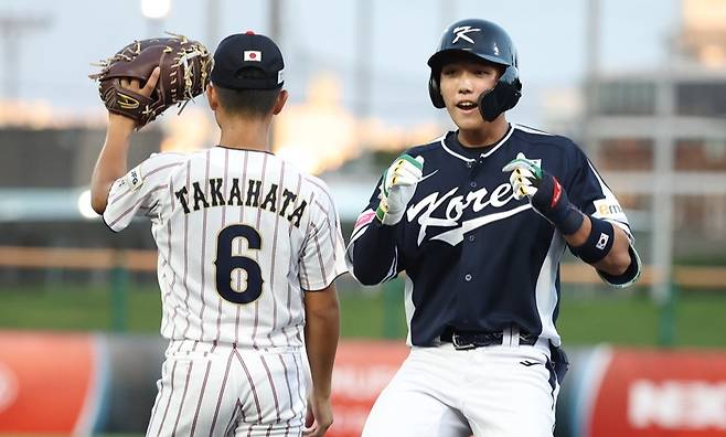 신재인(오른쪽)이 6일 일본 오키나와의 나하 셀룰러 스타디움에서 열린 2025 WBSC U-18 월드컵 A조 오프닝 라운드 2차전에서 안타를 기록한 뒤 기뻐하고 있다. 사진 WBSC 공식 홈페이지
