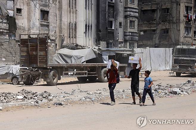 구호품 가지고 이동하는 가자 주민 [AFP 연합뉴스 자료사진. 재판매 및 DB 금지]