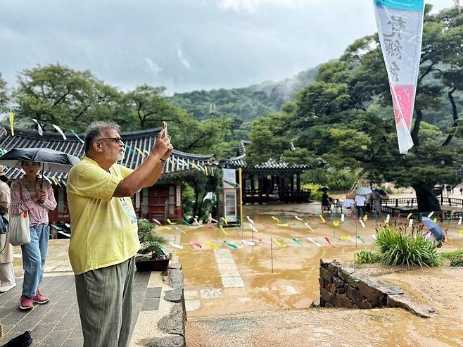 ▲지난 6일 인천 강화군 전등사를 찾은 마하트마 간디의 증손자 투샤르 간디 간디재단 이사장이 절의 풍경을 사진으로 담고 있다. /홍준기 기자 hong@incheonilbo.com