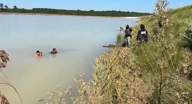美 이민당국이 공개한 현대차-LG엔솔 이민단속 사진. 중남미계로 보이는 직원들이 연못에서 단속 요원과 대치하고 있다./ ICE