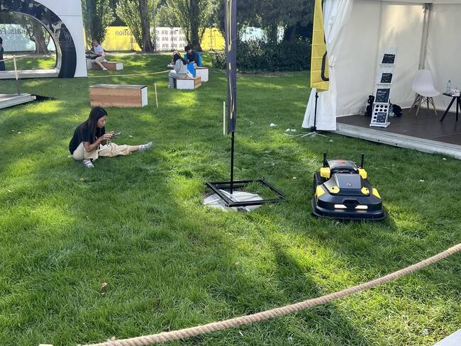 지난 5일(현지시각) 독일 베를린 국제 가전 전시회(IFA)의 야외 잔디밭에서 중국 청년이 스마트폰으로 자사의 잔디 깎이 로봇을 조종하고 있다. 박종오 기자