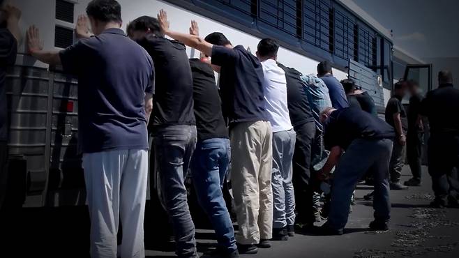 양손과 다리에 체인 묶는 단속요원들