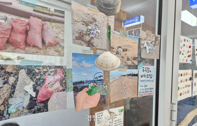 공방 ‘두두달’ 공방지기 김지언씨(39)가 동해 해변에서 촬영한 쓰레기 사진들이 지난 6일 강원 동해시 공방 ‘두두달’ 매장 유리 벽에 붙어있다. 김태욱 기자