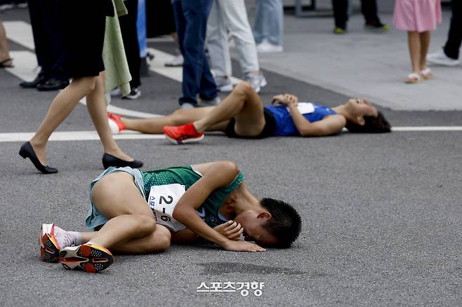 경향신문과 대한육상연맹이 공동 주최한 제55회 대통령기 전국통일구간마라톤대회가 열린 7일 경기 파주시 임진각 결승점을 통과한 선수들이 그대로 쓰러져 가쁜 숨을 내쉬고 있다. 문재원 기자