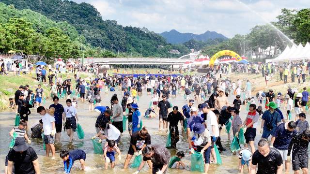 괴산 동진천 일대가 '고추물고기를 잡아라' 프로그램에 참가한 1000여 명의 인파로 발 디딜 틈 없이 북적이고 있다. 괴산군 제공