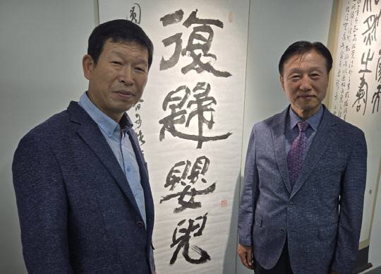 취묵헌기념관 이명복 사무국장과 이명규 회장(오른쪽)이 8일 취묵헌서예관에서 열린 개관기념 특별전시 '서여기인(書如其人) : 글씨는 그 사람을 닮는다'에 전시된 취묵헌 인영선 선생의 작품 '복귀영아' 옆에서 기념촬영을 하고 있다. 박하늘 기자