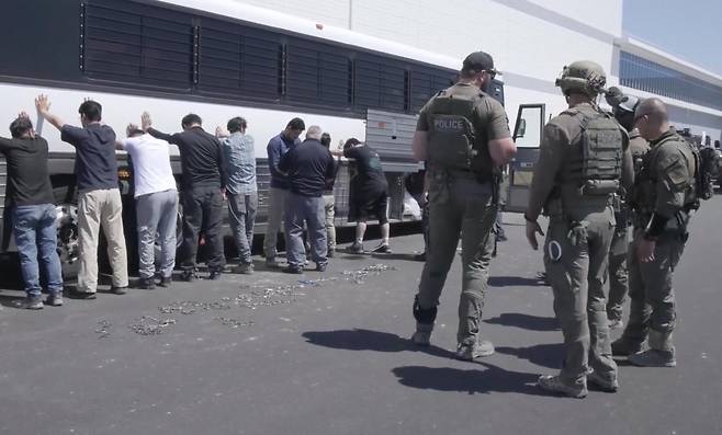 4일(현지 시간) 미국 조지아주 서배너의 현대차그룹-LG에너지솔루션 합작 배터리공장 건설 현장에서 이민세관단속국(ICE) 요원들이 불법 체류 혐의를 받는 한국인 공장 직원들을 버스에 양손을 짚게 하고 일렬로 세워놓은 모습. 요원들은 이들의 양손과 다리를 쇠사슬로 묶어 약 170km 떨어진 포크스턴 구금소 등으로 이동시켰다. 이 구금소는 오래전부터 열악한 환경으로 비판받았던 곳이다. 사진출처= ICE 홈페이지