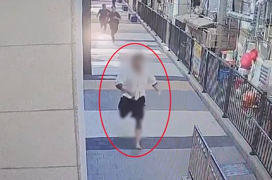 경찰의 불심 검문에 신고 있던 슬리퍼를 벗어 던지고 도주하는 강력사건 수배자. 사진 부산경찰청