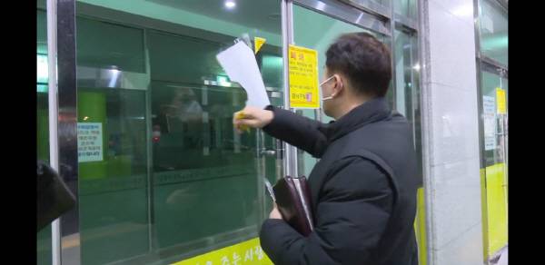 부산 세계로교회에서 손현보 담임목사가 구청에서 붙인 시설폐쇄 고지문을 떼어내고 있다.