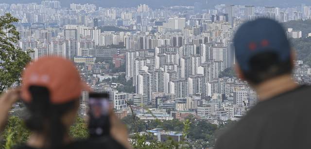 ‘잡히지 않는’ 서울 아파트  : 7일 정부가 2030년까지 수도권에서 매년 신규 주택 27만 가구 착공을 추진하는 내용의 주택공급 확대 방안을 발표한 가운데 시민들이 서울 중구 남산에서 시내 아파트 단지를 바라보고 있다.  백동현 기자