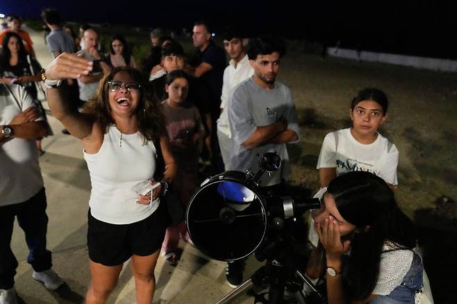 [베이루트=AP/뉴시스] 7일(현지 시간) 레바논 베이루트 시내에서 한 여성이 망원경으로 개기월식을 관측하고 있다. '개기월식'은 달이 지구 그림자에 완전히 가려지는 천문 현상이다. 2025.09.08.