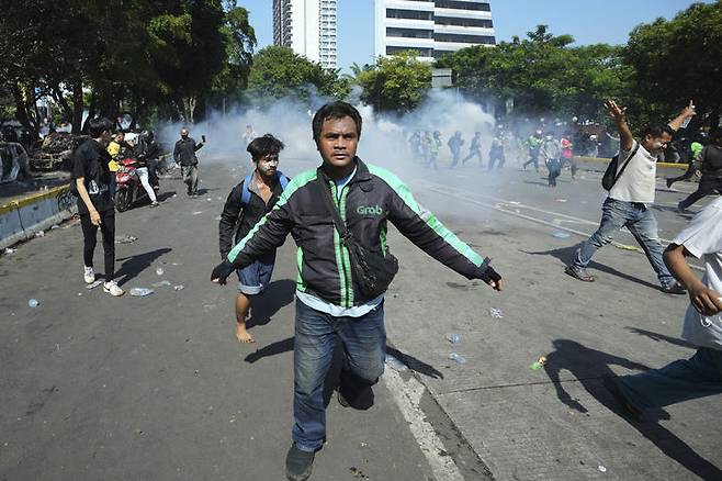 [자카르타(인도네시아)=AP/뉴시스]8월29일 인도네시아 자카르타에서 전날 국회의원들에게 지급되는 과도한 수당에 반대하는 집회 도중 경찰 장갑차에 치여 숨진 차량 호출 서비스 운전자를 추모하는 시위가 열린 가운데 시위대가 경찰 최루탄을 피해 흩어지고 있다. 프라보워 수비안토 인도네시아 대통령이 8일 2주 넘게 인도네시아 전역을 휩쓴 치명적인 반정부 시위 이후 스리 물랴니 인드라와티 재무장관을 경질하는 등 대규모 개각을 단행했다. 2025.09.08.