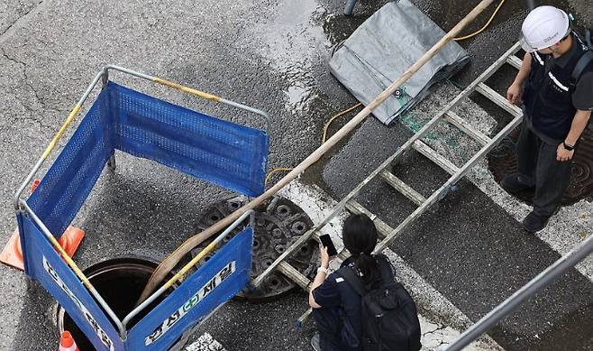 서울 염창동 맨홀에서 작업자 한 명이 내부로 휩쓸려 가는 사고가 발생, 관계자들이 현장에서 조사를 하고 있다. 연합뉴스