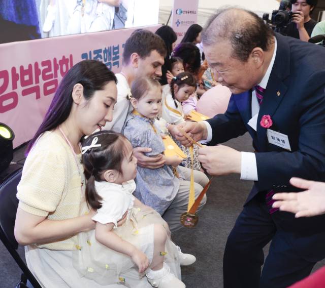 5일 부산 해운대구 벡스코 제1전시장에서 열린 큐티 베이비 부문 본선에서 양재생 부산상공회의소 회장이 아기들에게 메달을 걸어주고 있다. 정대현 기자 jhyun@