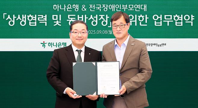 이호성 하나은행장(사진 왼쪽)이 윤종술 전국장애인부모연대 회장(사진 오른쪽)과 협약서를 들고 기념촬영을 하고 있다.  (하나은행 제공)