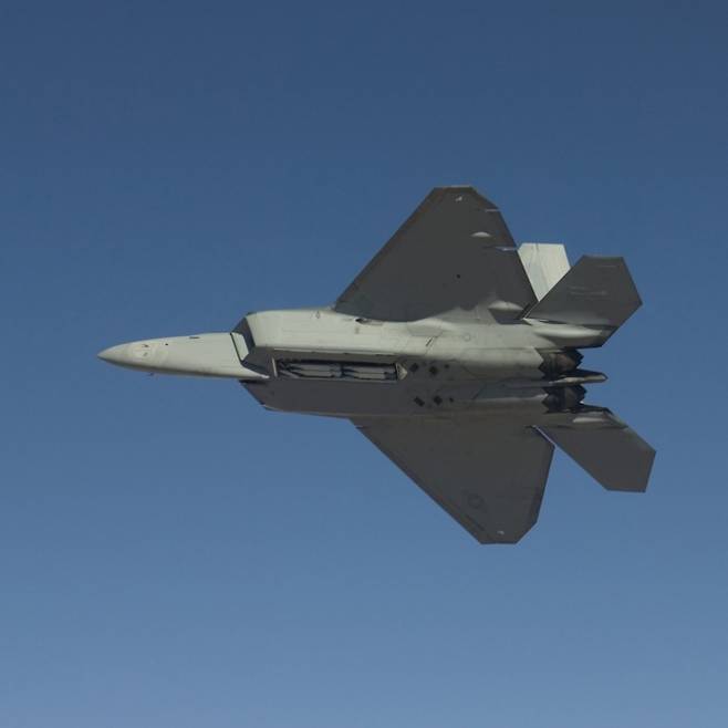 비행 중 무장창을 열어 탑재한 AIM-120 미사일이 보이는 F-22 랩터. 미 국방부 제공