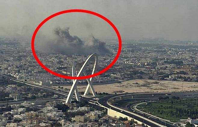 9일(현지시간) 카타르 수도 도하와 루사일시티를 연결하는 쌍곡선 아치형 교량 구조물 ‘알 와흐다 아치스’ 뒤로 폭발 연기가 보인다. 2025.9.9 텔레그램