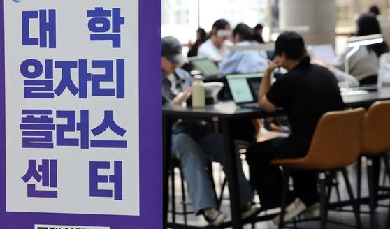 Students look over job information at a university job center in Seoul on Sept. 10. [YONHAP]