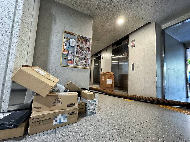 ▲&nbsp;11일 인천 계양구 작전동 한 주상복합 1층 출입구에는 승강기가 작동하지 않아 택배 상자가 쌓여있고, 그 옆으로는 복구 작업을 위해 지하로 연결된 파이프가 지나가고 있다. /홍준기 기자 hong@incheonilbo.com
